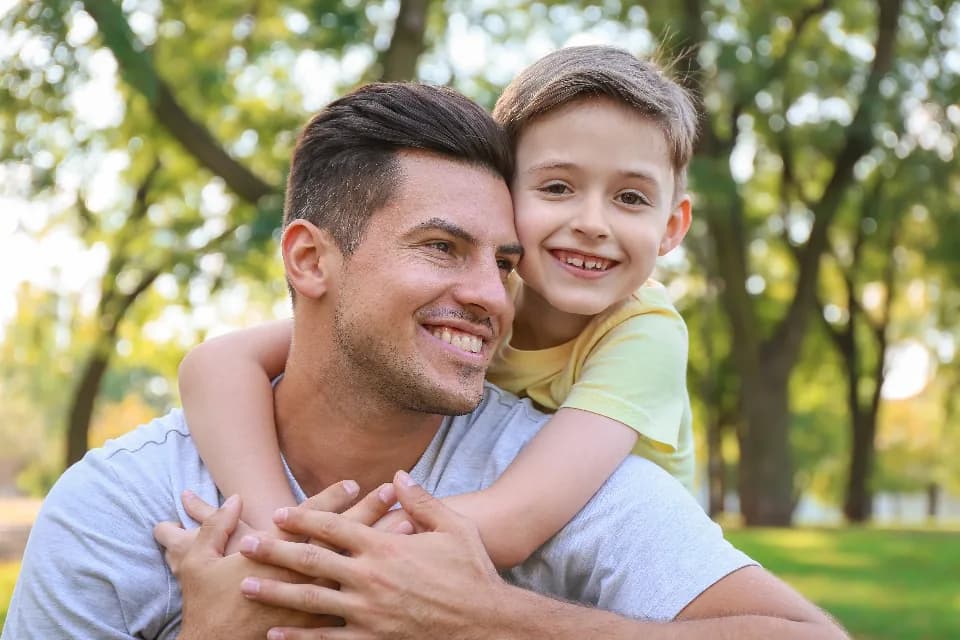 Papá abrazando a su hijo en el parque